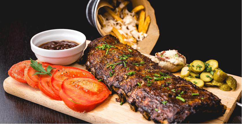 Charcoal-grilled ribs served with fresh tomato and sides